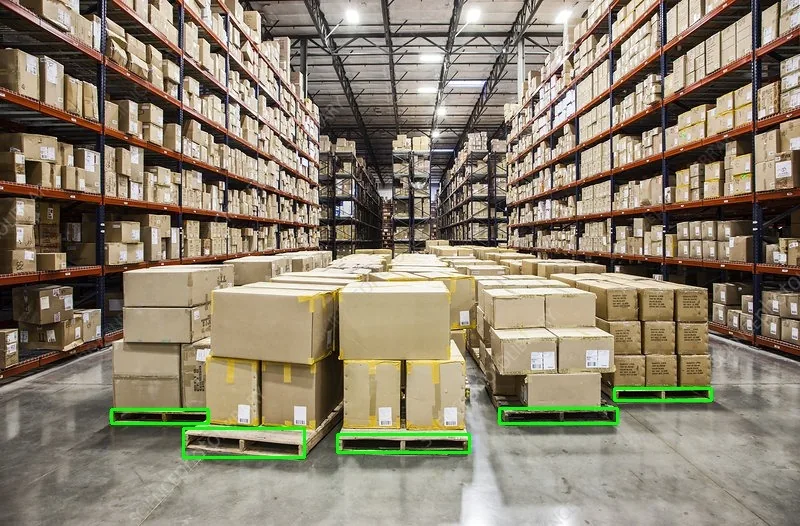Warehouse aisle with stacked pallets; AI vision highlights detected pallets in green